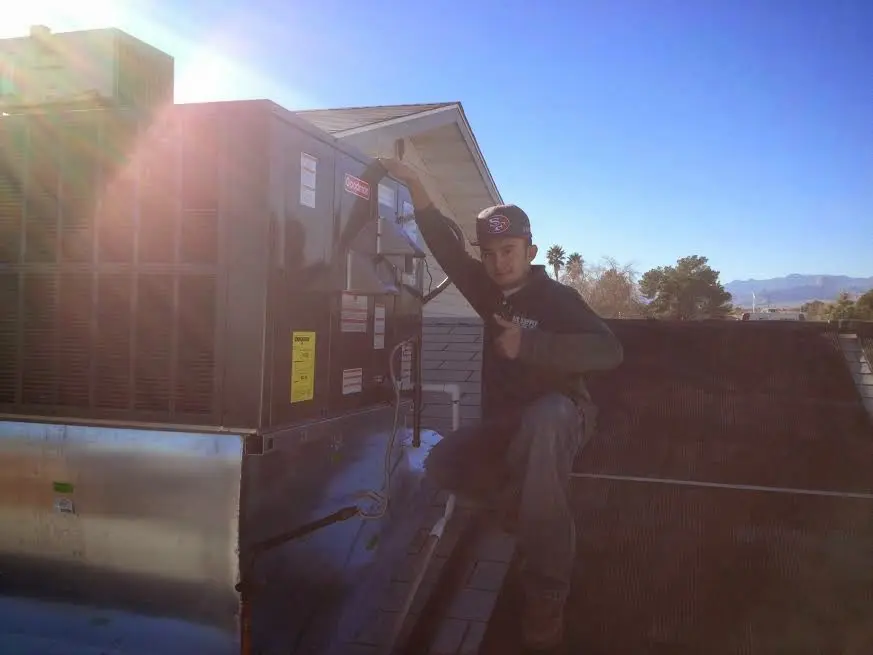 HVAC technician performing AC Tune-Up on a rooftop unit in Orinda